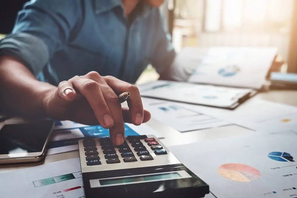 Man working at a desk with a calculator