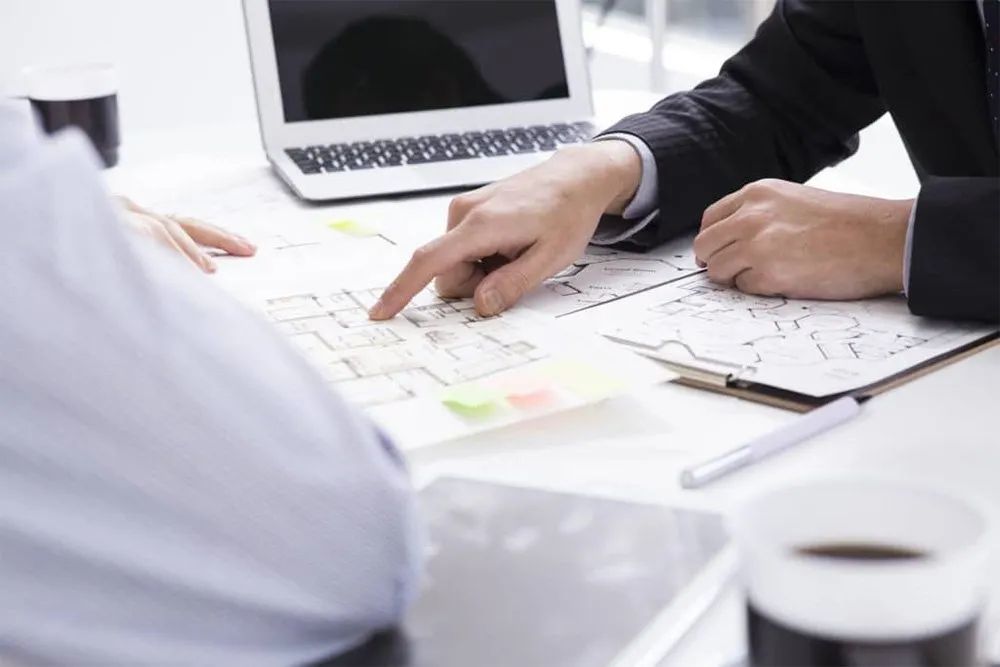 Person pointing to documents on desk
