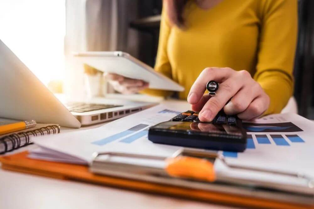 Woman using a calculator at desk